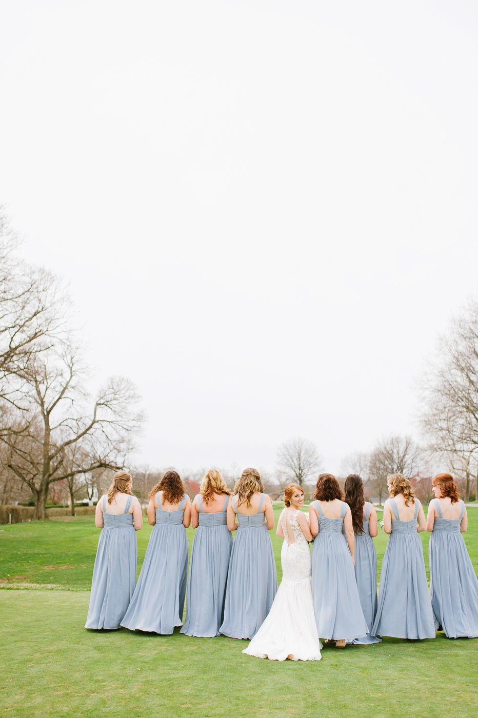 brides and bridesmaids walking on golf course