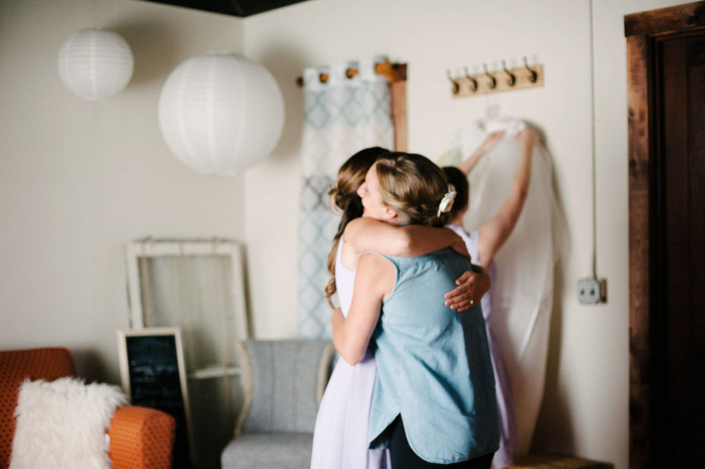 bridesmaid hugging bride on the morning of her wedding day