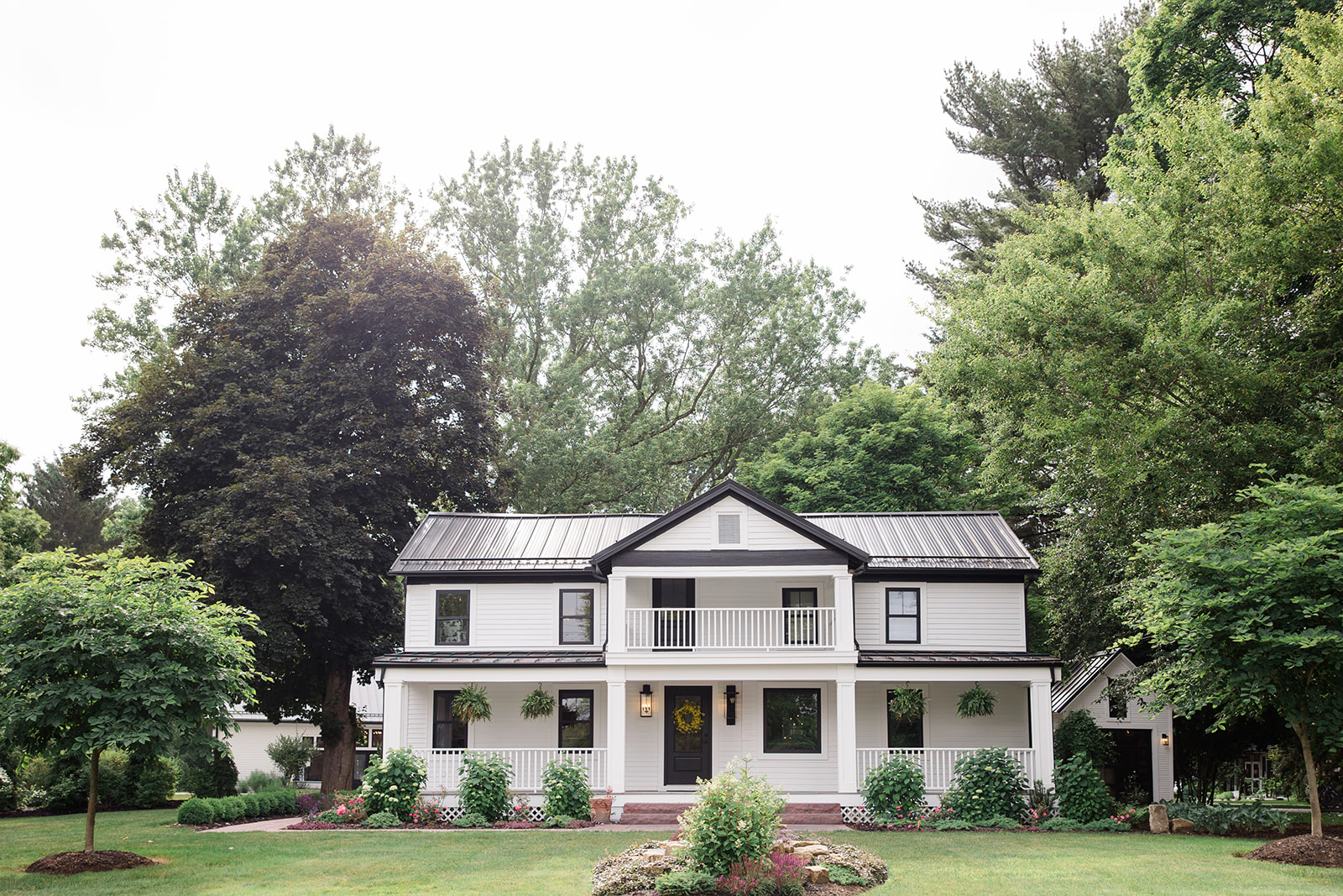 Front view of the 1840 Manor House surrounded by lush greenery and landscaped gardens, a popular venue captured by a Cleveland Wedding photographer for elegant outdoor ceremonies and receptions.