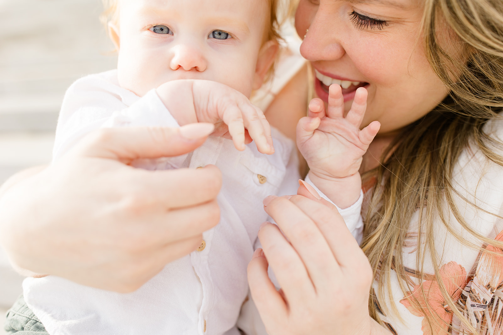 Mother holding baby during outdoor session with Cleveland family photographer and spring family photos in soft natural light.