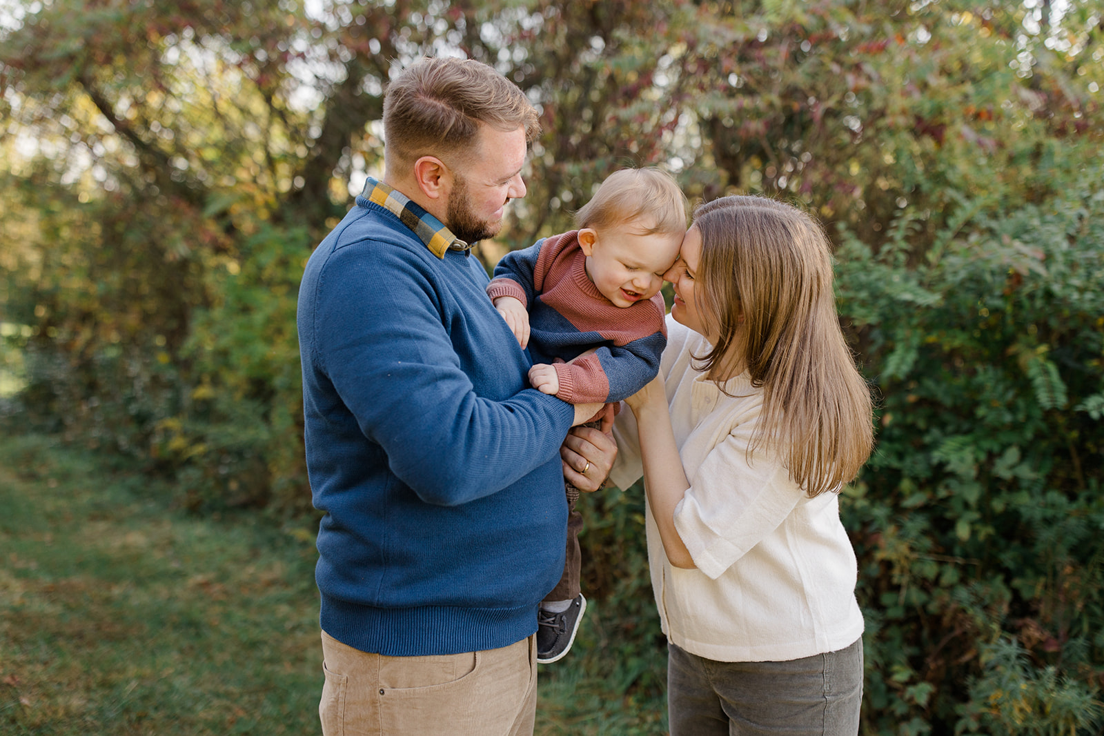 Family posing outdoors with a toddler in a wooded setting, ideal for Cleveland family photos by a Cleveland Family Photographer.